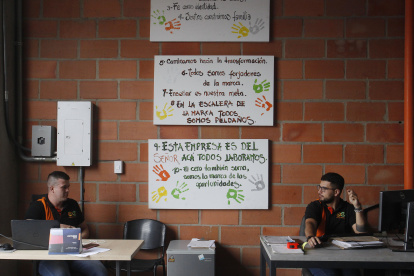 Dos hombres trabajan en la empresa Estanterías Metálicas Medellín.