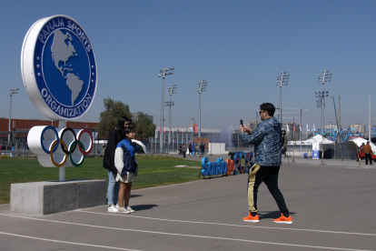 Varias personas se toman fotos afuera del Estadio Nacional. Es la primera vez que Chile acoge una cita de este tipo, pero deja dudas.