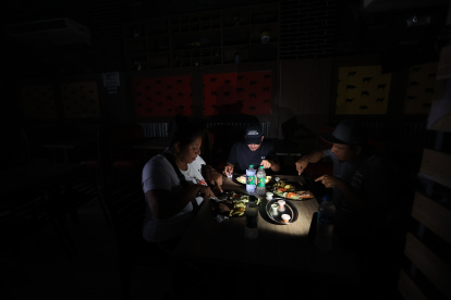 Restaurante. En Guayaquil, en la avenida 9 de Octubre, las personas  almuerzan a la luz de los celulares. En esta zona el corte de energía eléctrica ayer fue de 11:00 a 14:00.