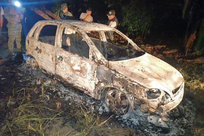 Escena. La policía busca indicios para saber quiénes eran las personas quemadas en la cajuela de un carro.