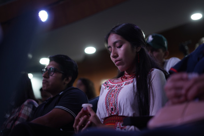 Una mujer indígena acude a una iglesia cristiana en Guayaquil junto a un alimento propio de la cultura