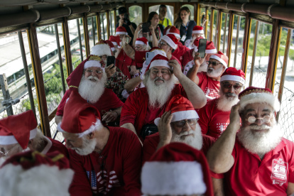 Hombres disfrazados de Papá Noel abordan el turístico "tranvía de Santa Tereza", en Río de Janeiro (Brasil)