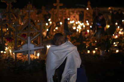 Familias se reúnen alrededor de las tumbas de sus seres queridos en la madrugada de hoy, en Pátzcuaro, estado de Michoacán (México). En el panteón municipal de la comunidad indígena de Arocutín celebran el Día de Muertos a través de la tradicional "Velada" donde el cementerio se convierte en un faro de luz en honor a los difuntos que han partido. EFE/ Iván Villanueva