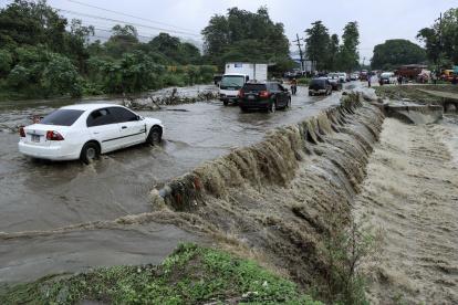 Tegucigalpa. Varios vehículos transitan por una carretera afectada por la creciente de agua en una quebrada.