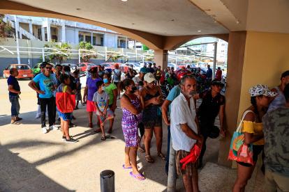 Personas hacen fila para adquirir productos en una tienda de autoservicio hoy, tras el paso del huracán Otis en el balneario de Acapulco, en el estado de Guerrero (México).