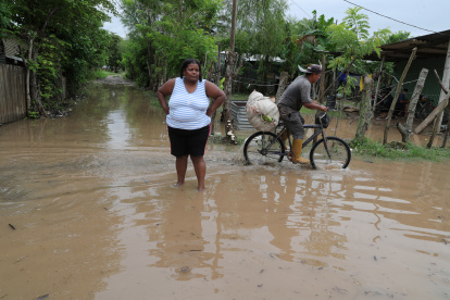 Residentes transitan una calle inundada hoy, en la Colonia Jehová Jireth del municipio de San Manuel, departamento de Corte (Honduras).