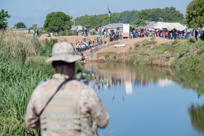Un militar dominicano hace vigilancia en el borde del río Masacre, frontera natural con Haití, en Dajabón (República Dominicana).