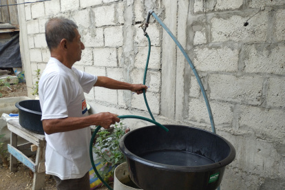Una persona se aprovisiona de agua ante el anuncio de suspender el servicio de manera imprevista en la península de Santa Elena.