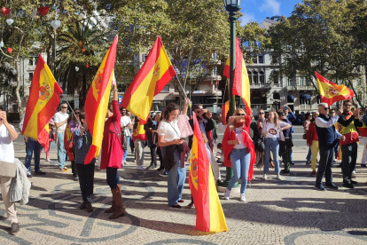 Un grupo de personas protesta, bandera en mano, este domingo contra la amnistía frente a la Embajada de España en Lisboa.