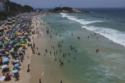 Fotografía aérea que muestra a miles de bañistas en la playa de Ipanema cuando se espera que la ciudad viva el día con más calor del año hoy, en Río de Janeiro (Brasil)