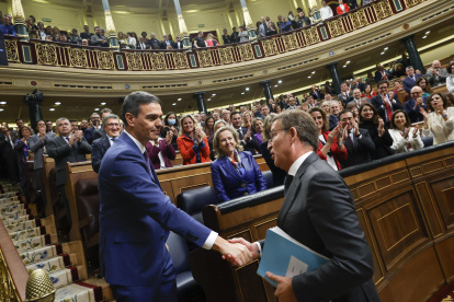 El líder del PP, Alberto Núñez Feijóo (d), felicita al presidente del Gobierno en funciones, Pedro Sánchez, al término de la segunda jornada del debate de investidura.