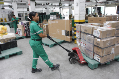 Trabajo.- Una mujer mueve la carga en Servientrega.