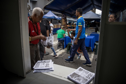 Caracas.  Un hombre toma un periódico del camión de información.