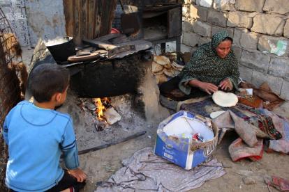 Pobreza. Una mujer  hace pan artesanal en una localidad de la Franja de Gaza, en una imagen de archivo