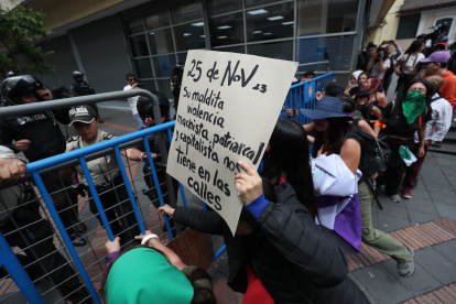 Varias personas se enfrentan con policías antidisturbios durante una marcha con motivo del Día Internacional de la Eliminación de la Violencia Contra la Mujer en Quito