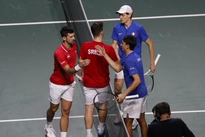 Los jugadores de la selección de Italia de tenis Jannik Sinner y Lorenzo Sonego (d) tras el saludo con los jugadores de Serbia Novak Djokovic y Miomir Kecmanovic.