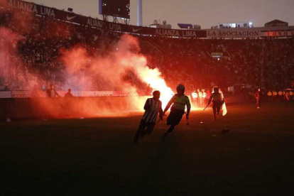 Hinchas ingresaron al campo de juego cuando las luces se apagaron.
