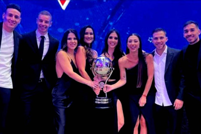 Los argentinos Mauricio Martínez (i), Adrián Gabbarini, Ezequiel Piovi y Lisandro Alzugaray (d) posaron con sus esposas y el trofeo de la Copa Sudamericana.