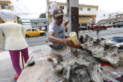 Monigoteros. El artesano Hugo Cruz añade almidón sobre una figura.