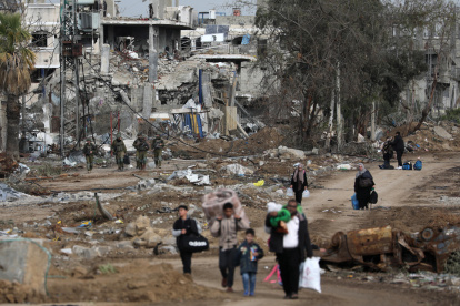 Palestinos caminan después de cruzar desde el norte de la Franja de Gaza al sur de la Franja de Gaza mientras los soldados israelíes avanzan por la carretera Salah Al Din en el centro de la Franja de Gaza, el 28 de noviembre de 2023.