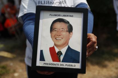 Fotografía de archivo en la que se registró a un seguidor del expresidente peruano Alberto Fujimori al sostener en sus manos una foto del exmandatario, en Lima (Perú).
