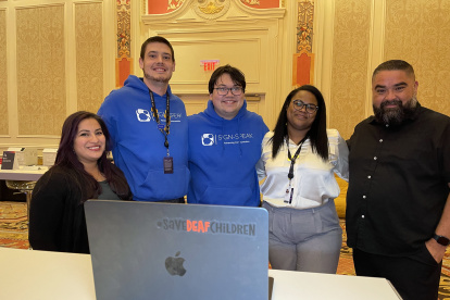 Los cofundadores de la aplicación Sign-Speak, Yamillet Payano (2d), y Nicholas Wilkins (c), posan junto a los intérpretes del Departamento de Personas con Discapacidad de Amazon.