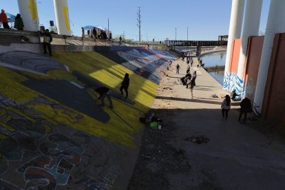 Activistas pintan un mural para denunciar la violencia de género y el maltrato a los migrantes, junto al río Bravo en Ciudad Juárez, estado de Chihuahua (México).
