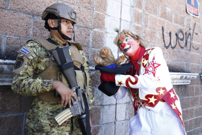 Un payaso bromea con un soldado durante un desfile con motivo del día del payaso salvadoreño hoy, en San Salvador (El Salvador).