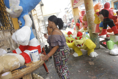 En la tradicional calle 6 de Marzo, varios artesanos están terminado de pintar algunos muñecos para ponerlos en venta.