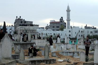 Gaza. Palestinos aparecen en cementerio de un campo de refugiados.