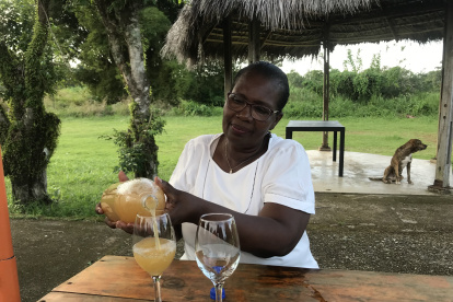 Nidia Cortez sirve en una copa el guarapo y explica cómo beberlo.