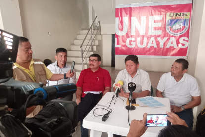 Dirigentes de la Unión Nacional de Educadores, entre ellos Jorge Escala (de rojo) e Hilario Beltrán (hablando), denunciaron la mora patronal de 23 distritos de Guayas.