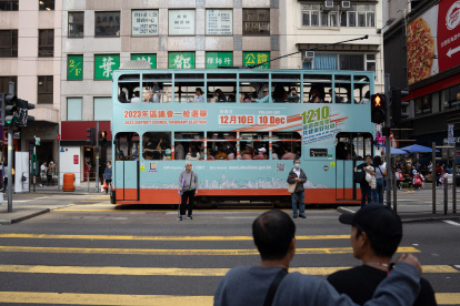 Hong Kong (China), 10/12/2023.- A tram displaying the advertisement of the District Council Ordinary Election drives past in Hong Kong, China, 10 December 2023. This is the first election after its reform in May 2023 which aims at ensuring only "patriots" are elected. The directly elected seats will be slashed to around 20 percent under the electoral overhaul. (Disturbios) EFE/EPA/BERTHA WANG