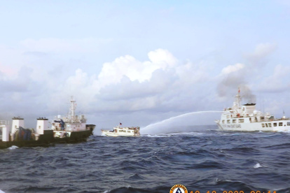 Un barco de la Guardia Costera China (D) disparando cañones de agua contra un barco de suministro operado por la Armada de Filipinas (M/L Kalayaan) (C) en el disputado mar de China Meridional el 10 de diciembre de 2023.