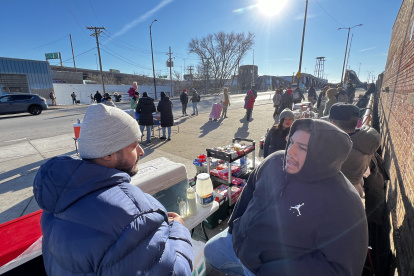 Vendedores ambulantes disponen sus mesas para vender sus productos en las afueras de un albergue, el 12 de diciembre de 2023, en la ciudad de Chicago, Illinois (EE.UU.).