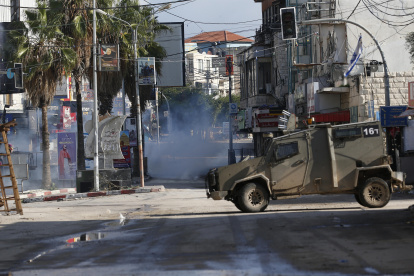 Jenin. Un vehículo militar israelí en medio de los gases lacrimógenos cerca a un campo de refugiados.
