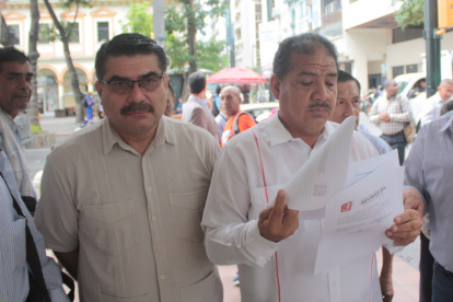 Los dirigentes Jorge Escala y Alonso López, de Unidad Popular, muestran la denuncia presentada en la Fiscalía.