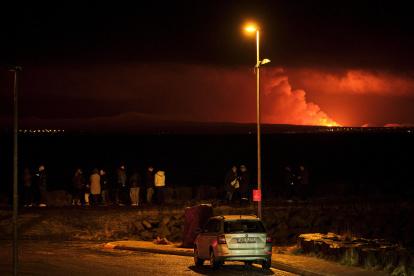 Grindavík (Islandia). Un grupo de personas observa a lo lejos la erupción.