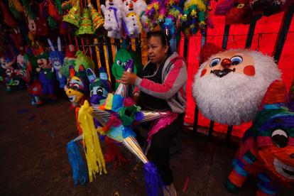 Labor. Una persona en México trabaja en un local donde se elaboran y se venden las típicas piñatas.