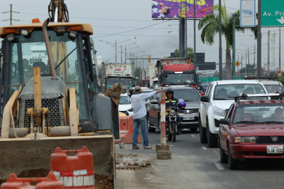 25 de Julio. Un trabajador dirige el tránsito que se forma en paralelo al inicio del puente en construcción.