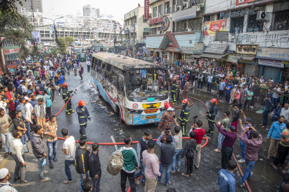Una gran cantidad de personas rodean el autobús que se incendió ayer en la ciudad de Dacca, este 19 de diciembre de 2023.