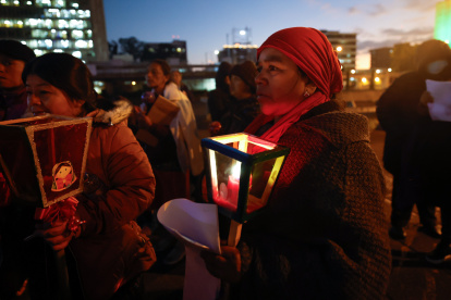 Un grupo de mujeres indígenas acompaña con velas una posada navideña contra la corrupción para exigir el "respeto a la democracia".