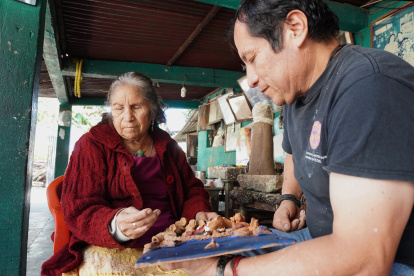 Los artesanos Josefina Aguilar (i), y su hijo Demetrio, elaboran nacimientos miniatura de barro, el 23 de diciembre de 2023, en la ciudad de Oaxaca (México).
