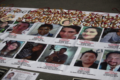 Detalle de un cartel registrado el pasado 22 de diciembre con imágenes de personas desaparecidas, frente al Palacio Nacional, en Ciudad de México (México).