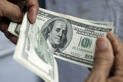 MANOS CONTANDO DINERO O BILLETES DE CIEN DÓLARES |