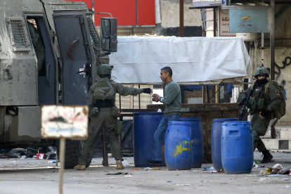 Nablus (-), 31/12/2023.- Israeli soldiers detain a Palestinian man during an Israeli army raid on the Askar refugee camp, on the outskirts of the West Bank city of Nablus, 31 December 2023. According to the Palestinian Health Ministry, at least five Palestinians were wounded and two arrested during the Israeli military raid and ensuing clashes at the Askar refugee camp. EFE/EPA/ALAA BADARNEH