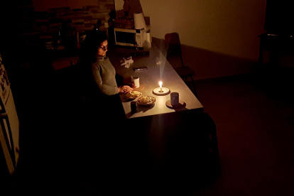 Problemas. Una ciudadana intenta comer en medio de la penumbra.