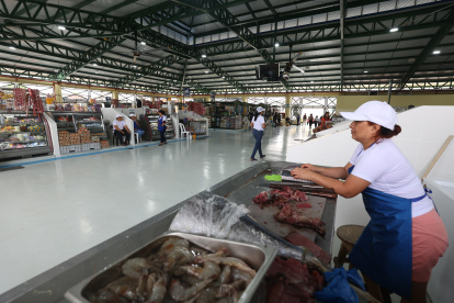 1. Mercado. Los comerciantes regularizados esperan impacientes recibir a los clientes que llegan poco.