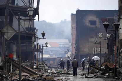 Wajima. Dos personas miran estructuras dañadas por el terremoto.