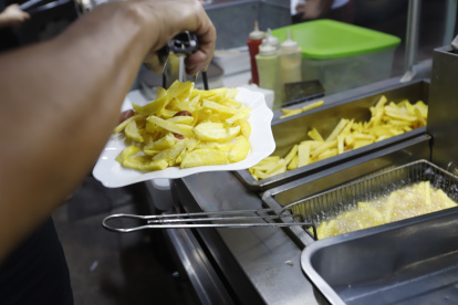 Local. El ayudante en uno de los locales, especializado en la salchipapa y papipollo, fríe la papa.